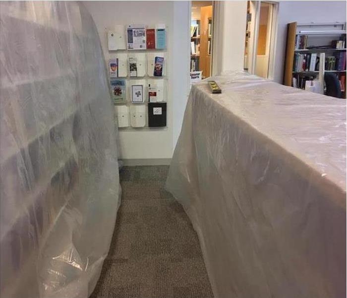 polyethylene sheeting over bookcases in a library