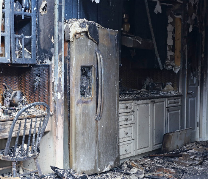 a fire damaged kitchen with debris littering the flood